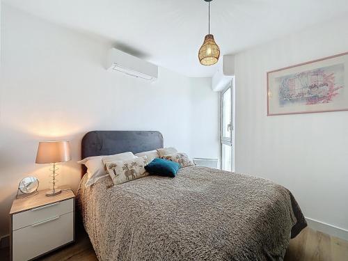 - une chambre avec un lit et une lampe sur une table de chevet dans l'établissement Appartement sur plage avec parking privé pour 4 pers - FR-1-715-107, à Mauguio