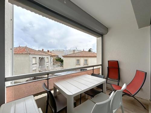 une table et des chaises sur un balcon avec une fenêtre dans l'établissement Appartement sur plage avec parking privé pour 4 pers - FR-1-715-107, à Mauguio