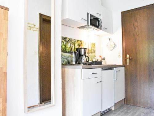 une cuisine avec des armoires blanches et un évier dans l'établissement Apartment Studio Esche 2 by Interhome, à Ellmau