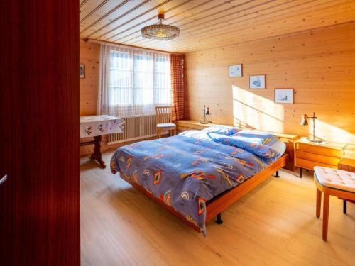 a bedroom with a bed in a wooden room at Apartment Berna 2- Stock by Interhome in Lenk