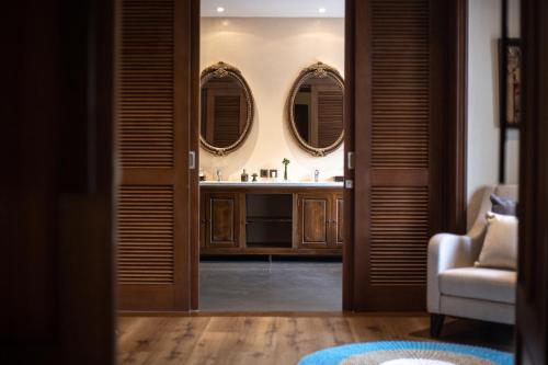a bathroom with a sink and two mirrors at Plataran Komodo Resort & Spa - CHSE Certified in Labuan Bajo