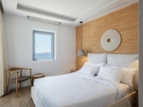 a bedroom with a large white bed and a window at Villa DM by Ethos Hospitality in Agios Ioannis Mykonos