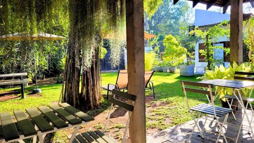 a patio with a table and chairs and a tree at The Ivy Lake in Anuradhapura