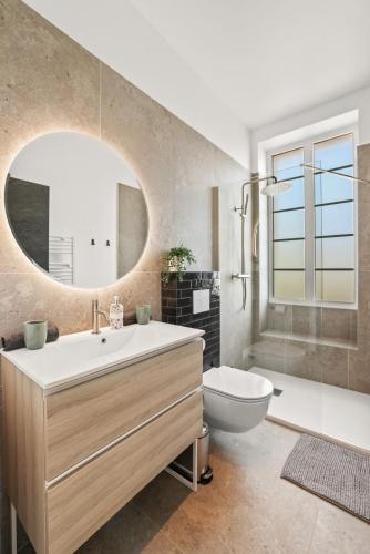 une salle de bain avec un lavabo, des toilettes et un miroir dans l'établissement Central Luxurious Property, à Antibes