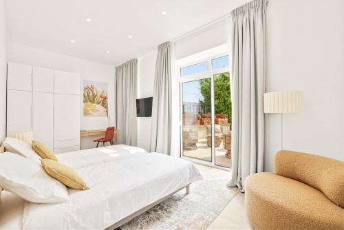 une chambre blanche avec un lit et une chaise dans l'établissement Central Luxurious Property, à Antibes