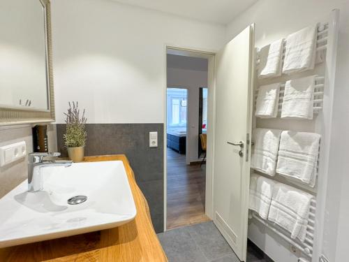 ein weißes Badezimmer mit Waschbecken und Spiegel in der Unterkunft Exklusives 3 Zi Design Apartment in FR-Altstadt in Freiburg im Breisgau