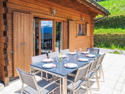 a blue table and chairs on a patio at Chalet La Truffe-2 by Interhome in Plan Fey