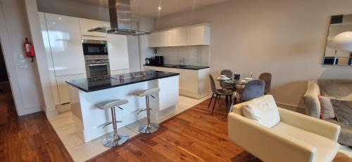 a kitchen and living room with a counter and a table at Slick & Stylish - Large 1Bd in Heart of Cork City in Cork