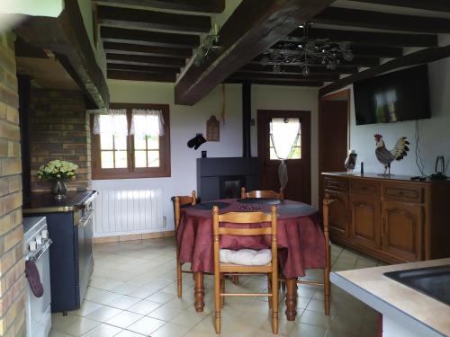 une cuisine avec une table et des chaises dans une pièce dans l'établissement Au relais de la forêt d'eawy, à Les Grandes-Ventes