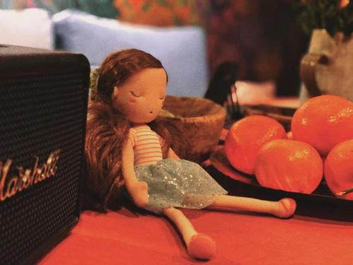 a doll sitting on a table next to oranges at 沙溪坡上村花隐世民宿 in Diannan