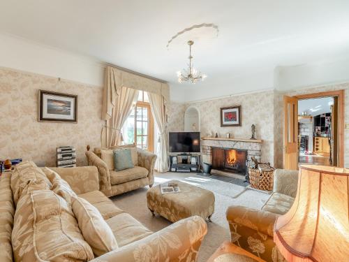 a living room with a couch and a fireplace at The Old Farmhouse in Ancroft