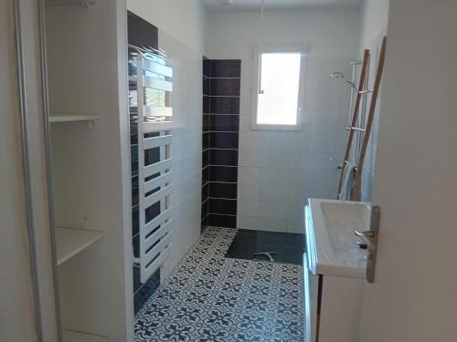 un baño con lavabo y ducha en Maison de vacance à la mer, en Les Sables-dʼOlonne