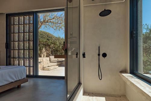 a bedroom with a glass door with a view of a tree at OPENNESS House by the sea in Marathi