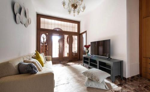 Una sala de estar con un sofá y un televisor. en Central Apartment Ca' dei Ferro - MURANO Venice, en Murano