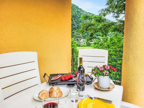 a table with a bottle of wine and bread on it at Apartment Appartment sulle Viti by Interhome in Losone
