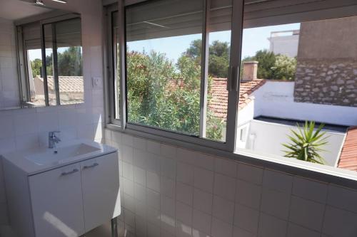 une salle de bain avec un lavabo et une fenêtre dans l'établissement Le Dauphin du port, à Port-la-Nouvelle