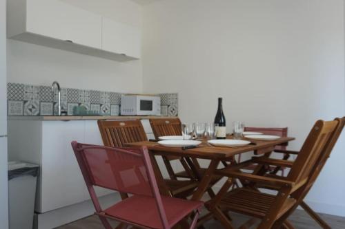 - une table à manger avec des chaises et une bouteille de vin dans l'établissement Le Dauphin du port, à Port-la-Nouvelle