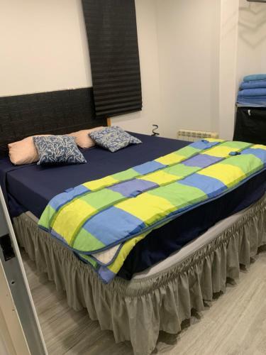 ChiloechesにあるApartamento con piscinaの青と黄色の掛け布団が敷かれた大きなベッド