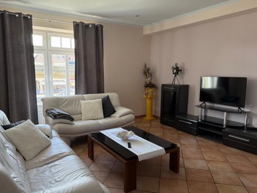 a living room with two couches and a tv at Ferienwohnung 2 beim Restaurant Rhodos in Heide