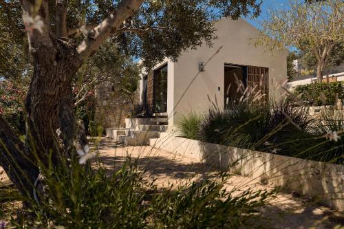 a house with a tree and stairs to the door at OPENNESS House by the sea in Marathi