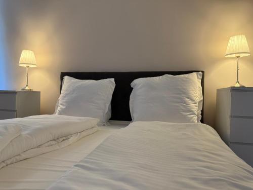 a bedroom with two beds with white sheets and two lamps at Ferienwohnung 2 beim Restaurant Rhodos in Heide