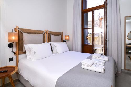 a bedroom with a large white bed with towels on it at Marea Boutique Suites in Rethymno