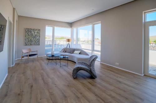 a living room with a couch and a table at Hofsbot Luxury Penthouse Apartment in Akureyri