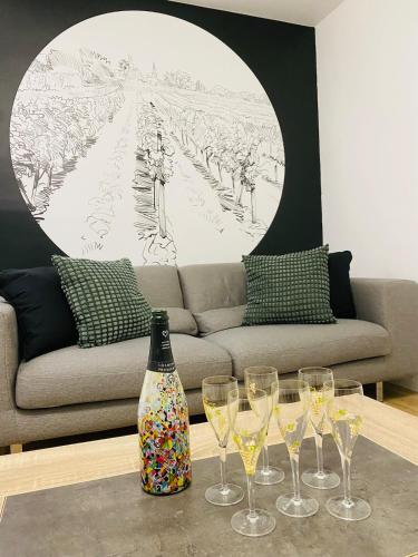 un groupe de verres à vin sur une table avec un canapé dans l'établissement La P'tite Maison Vaudon, à Avize