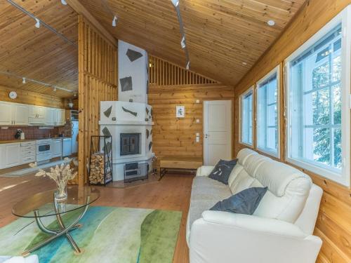 ein Wohnzimmer mit einer weißen Couch und einem Kamin in der Unterkunft Holiday Home Jerisrannantie 7 by Interhome in Rauhala