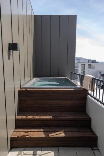 a hot tub on the balcony of a building at Hofsbot Luxury Penthouse Apartment in Akureyri