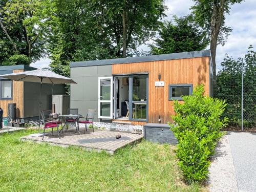 a tiny house with a table and chairs in a yard at Holiday Home Tiny Haus wildLoisl by Interhome in Beilngries
