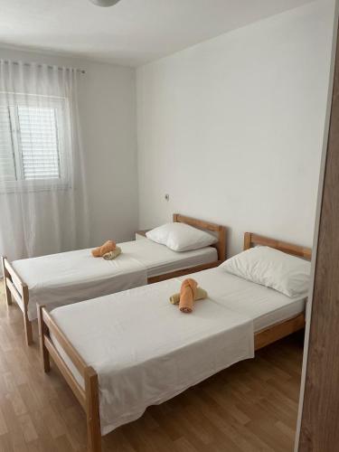 a bedroom with two beds with stuffed animals on them at Apartment MJ in Čapljina