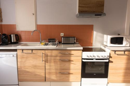 une cuisine avec une cuisinière et un micro-ondes dans l'établissement Maison avec parking la Flocellière, à La Flocellière