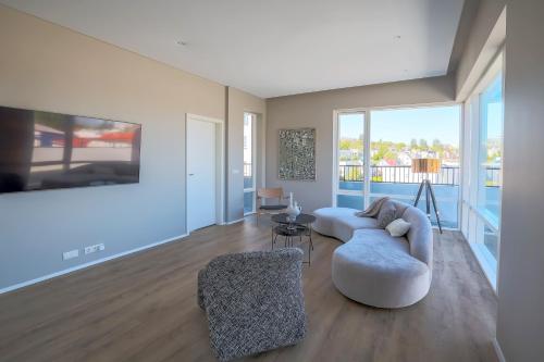 a living room with a couch and a chair at Hofsbot Luxury Penthouse Apartment in Akureyri