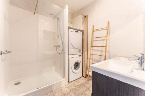 une salle de bain avec un lavabo et une machine à laver dans l'établissement Exceptionnel appartement avec vue Place de la Comédie, à Montpellier