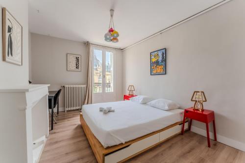 - une chambre blanche avec un lit et une table rouge dans l'établissement Exceptionnel appartement avec vue Place de la Comédie, à Montpellier