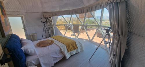 a room with a bed in a tent with a window at Dome Bally Kampia in Kambiá