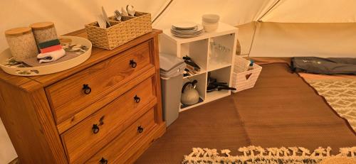 a room with a wooden dresser and a tent at Sŵn Y Môr bell tent