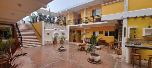 un immeuble d'appartements avec une cour intérieure agrémentée de plantes en pot dans l'établissement Hotel Iker, à Tulum