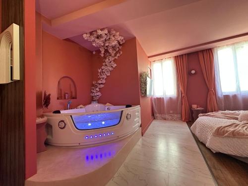 a bath tub in a room with a bedroom at LE LOVE-ROOM, Jacuzzi, Hyper-centre in Mâcon