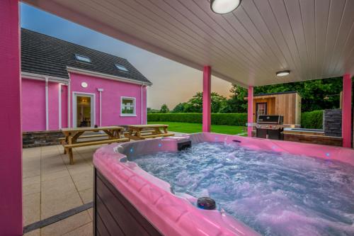 a hot tub in the backyard of a pink house at Lilys Pink House in Mayobridge