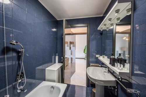 a blue bathroom with a sink and a tub at Private Parking - Sea View - Terrace - AC in Lavagna