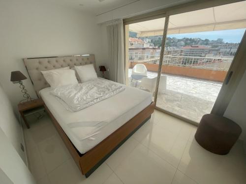 une chambre avec un lit et une grande fenêtre dans l'établissement Apt Cannes Centre - Proche des Plages et du Palais des festivals - Climatisation - Parking privée, à Cannes