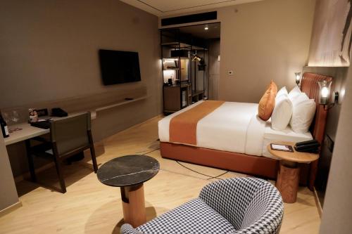 a hotel room with a bed and a chair at Ramada Encore by Wyndham Chandigarh Zirakpur in Zirakpur