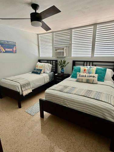 a bedroom with two beds and a ceiling fan at Seaside Apartment Steps to Breathtaking Sunrise in Luquillo