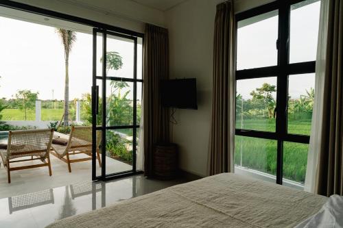 a bedroom with a bed and a large window at Villa Alaya No 4 in Cemagi