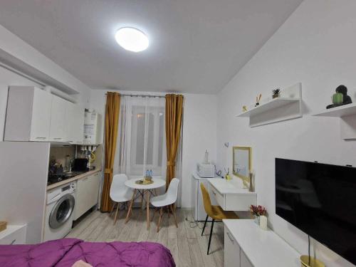 a white kitchen with a table and a sink and a room at Fortuna Brevis in Onești