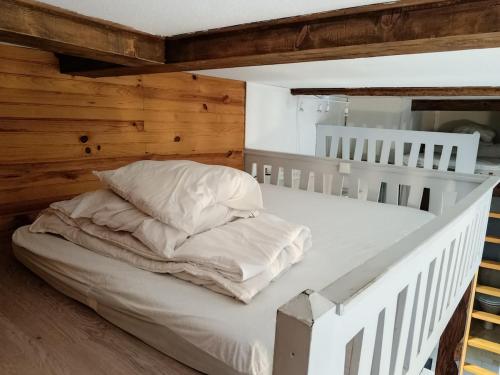 a bed with white sheets and pillows in a room at Le Nid Des Marmottes in Cauterets