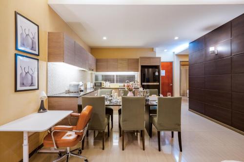 a kitchen and dining room with a table and chairs at The Ville Jomtien- 3 Bedrooms Deluxe Pool Villa in Jomtien Beach