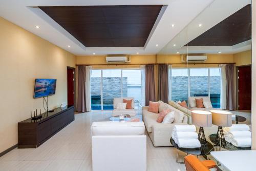 a living room with white furniture and windows at The Ville Jomtien- 3 Bedrooms Deluxe Pool Villa in Jomtien Beach